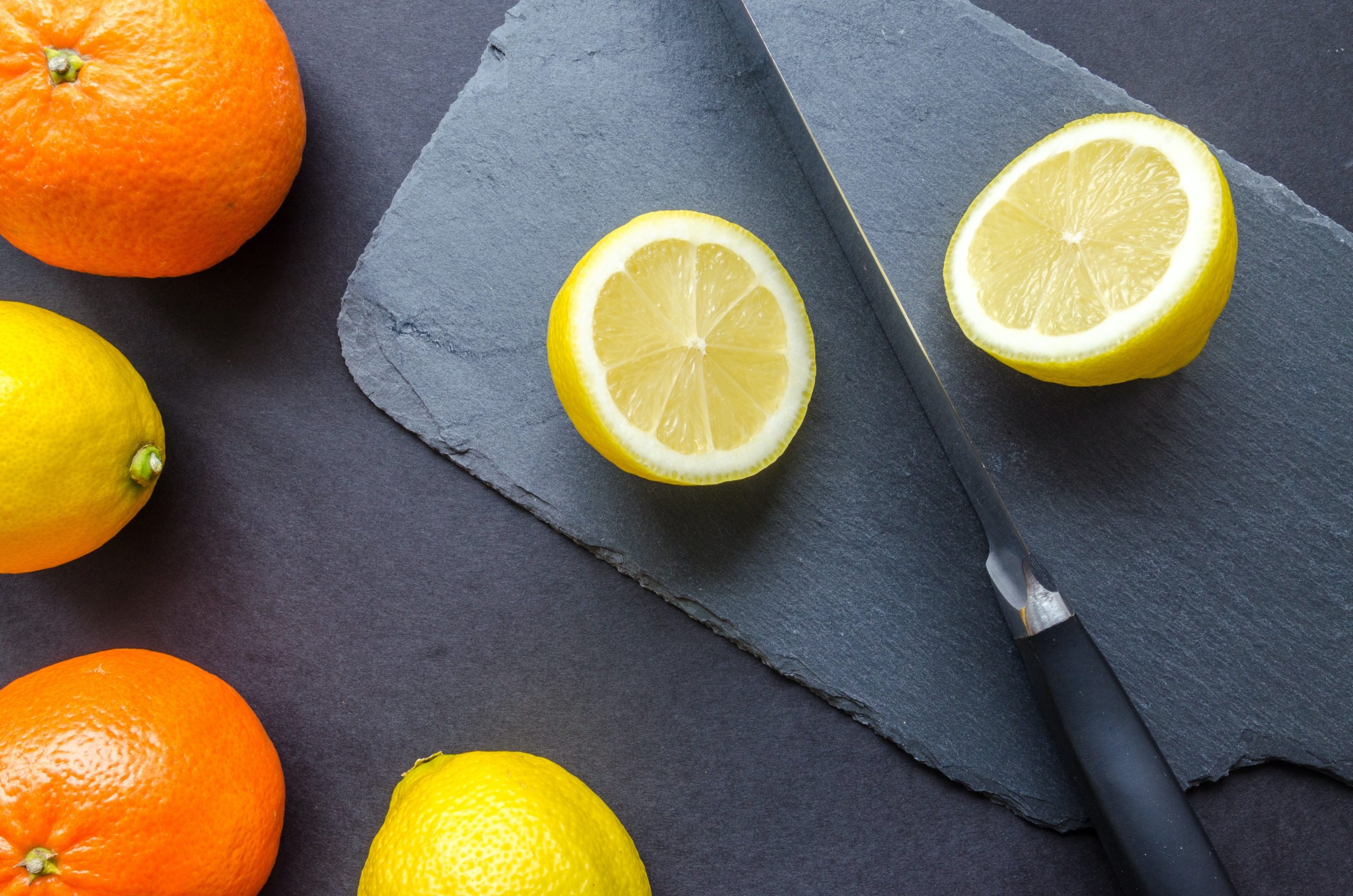 two-orange-and-three-lemons-on-gray-surface-952378-min