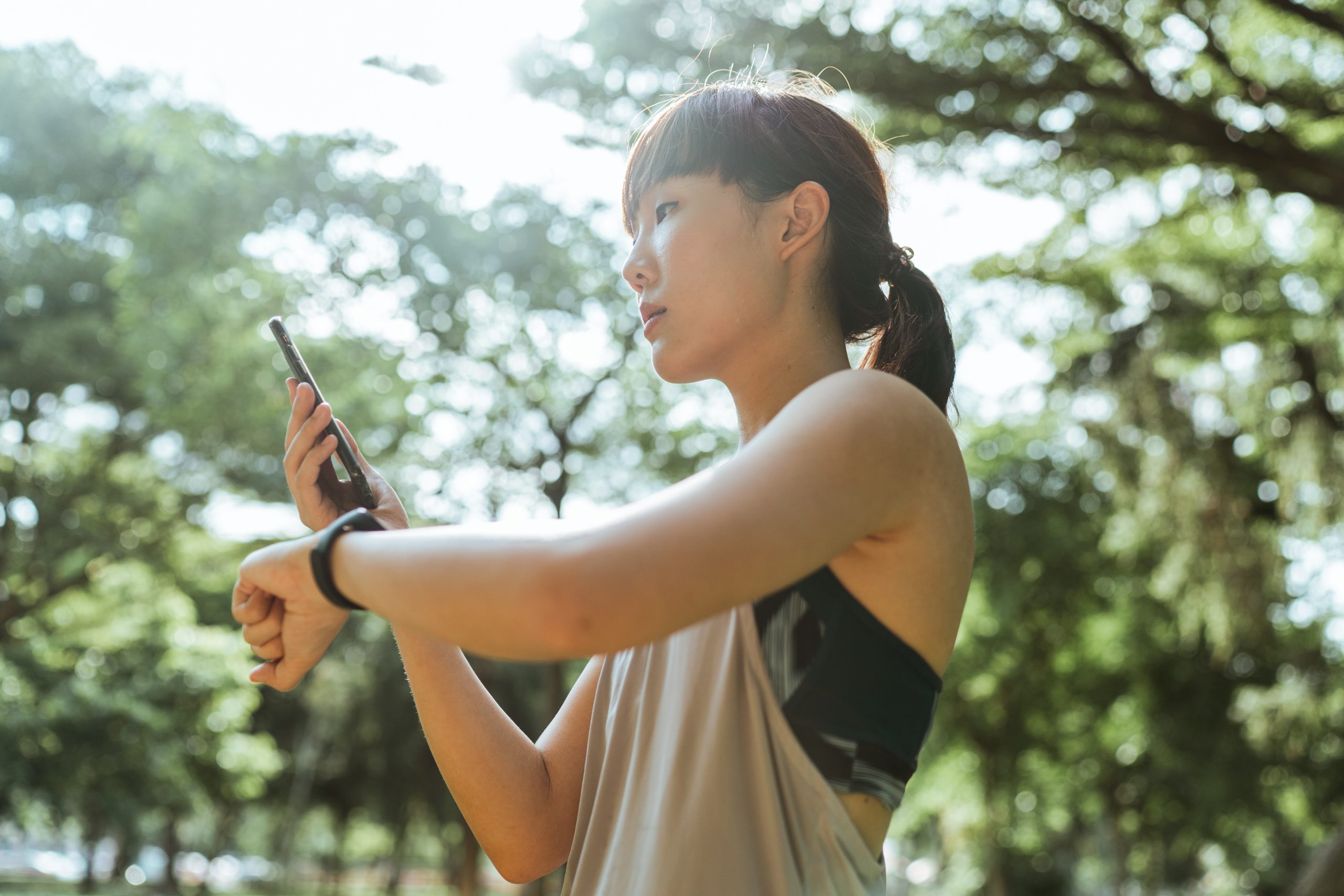 young-asian-woman-using-devices-for-fitness-in-park-4428993